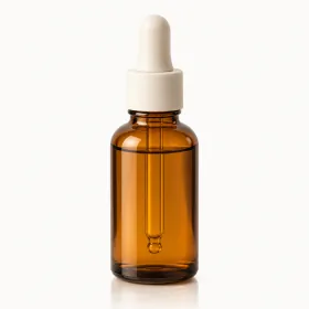 An unbranded amber glass dropper bottle with a cream cap, photographed straight on against a plain near-white background.